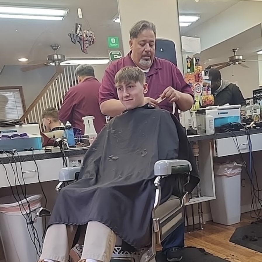 Barber finishing a haircut at the chair